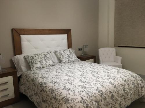 隆达新隆达公寓的一间卧室配有一张床和一把椅子