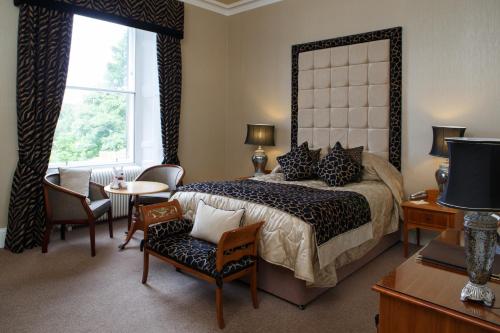 邓弗姆林加沃克之家酒店的卧室配有一张床和一张桌子及椅子