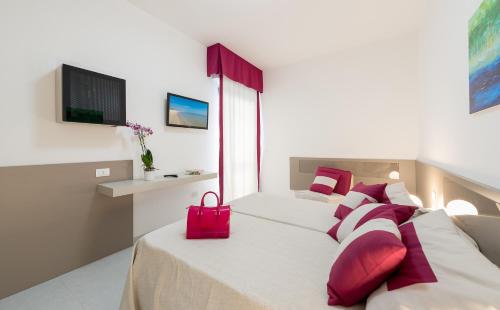 朱利亚诺瓦泽尼特酒店 的一间卧室配有两张带红色枕头和红色袋子的床