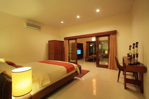 吉利特拉旺安阿南达普莱维特别墅的一间卧室配有一张床、一张桌子和一张书桌