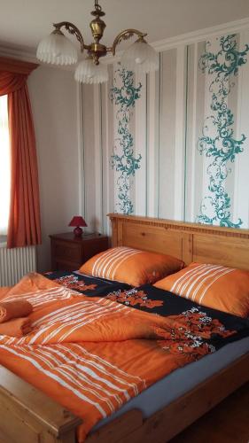 巴拉顿菲赖德Bruckner Villa Apartman的一间卧室配有两张带橙色床单的床