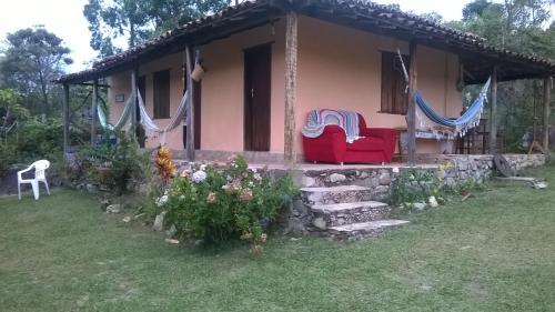 米洛韦吉Pousada Sempre Viva的院子里有两把红色椅子的房子
