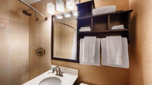 沃特敦贝斯维斯特水城/鼓堡酒店的浴室配有盥洗盆、镜子和毛巾