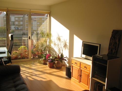 里斯本里斯本机场公寓的一间带电视和滑动玻璃门的客厅
