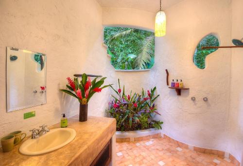 戈尔菲托Playa Nicuesa Rainforest Eco Sanctuary的一间带水槽和花瓶的浴室