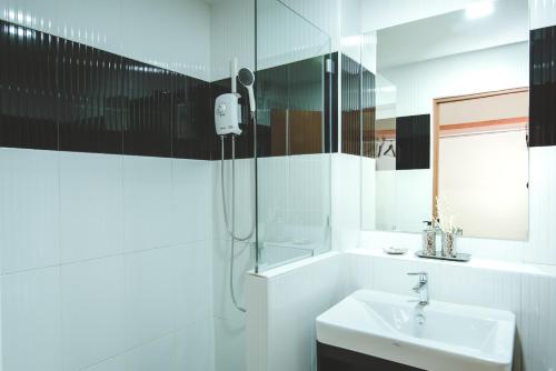 呵叻呵叻弗罗特公寓式酒店的白色的浴室设有水槽和淋浴。