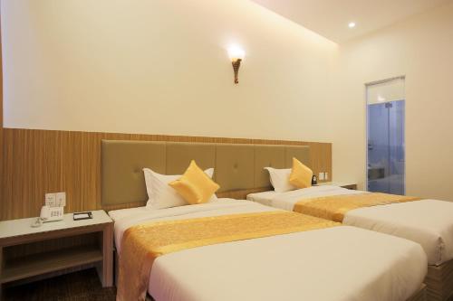 岘港红宫酒店的酒店客房设有两张床和窗户。