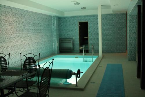 希卢泰Gilija的一个带椅子和桌子的房间的游泳池
