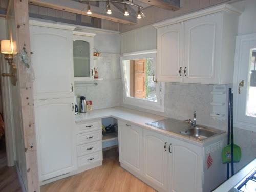 莱德罗Casa Carla的厨房配有白色橱柜和水槽