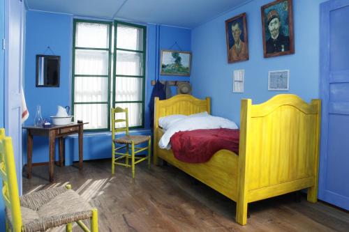 博克斯梅尔富贵餐厅酒店的一间卧室设有黄色的床和蓝色的墙壁
