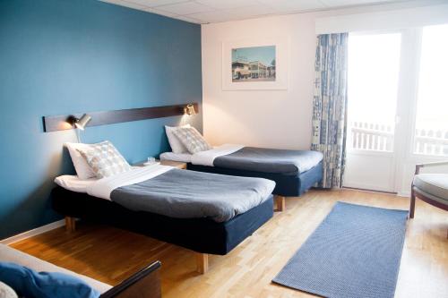 格兰纳Vätterleden Hotell & Restaurang的酒店客房,设有两张床和一张沙发