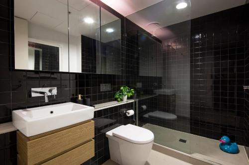 墨尔本墨尔本港海滩公寓的一间带水槽、卫生间和镜子的浴室