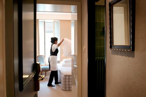 苏黎世金德里酒店的站在窗外的房间里的一个女人