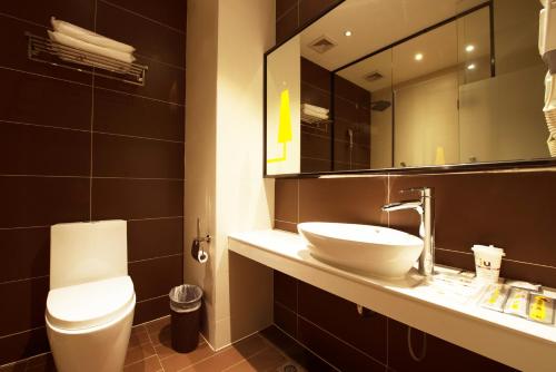 XinzhengzhanIU酒店·郑州新郑西亚斯学院店的一间带水槽、卫生间和镜子的浴室
