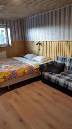 派尔努特尔斐旅舍的一间卧室配有一张床和一张沙发