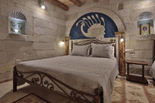 格雷梅维斯塔窑洞酒店的石墙客房的卧室配有一张床