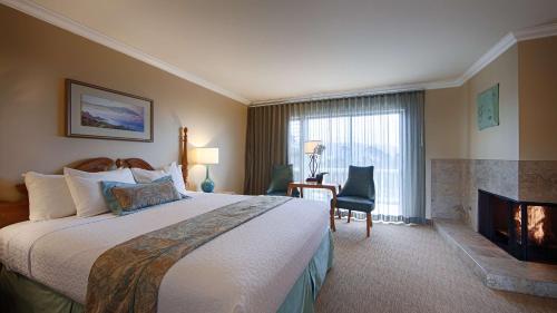 卡梅尔卡梅尔湾景酒店的酒店客房设有一张大床和一个壁炉。
