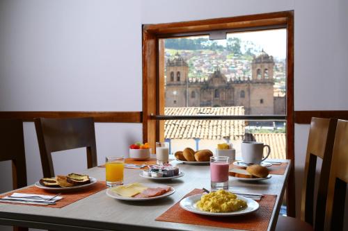 库斯科安迪纳之标准库斯科广场酒店的一张带早餐食品的桌子,享有城市美景