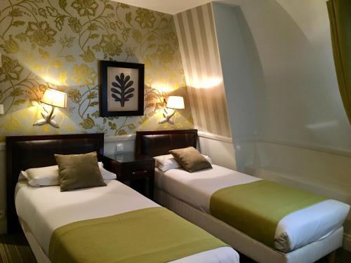 巴黎埃利塞公寓式酒店的酒店客房设有两张床和两盏灯。