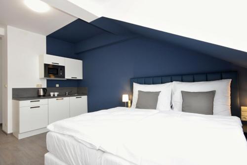 布拉格阿尔维奥套房酒店的一间卧室设有一张蓝色墙壁的大床