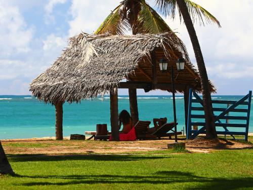 嘎林海斯港雅乐斯德德玛拉赛普旅馆的坐在海滩上草屋下椅子上的女人