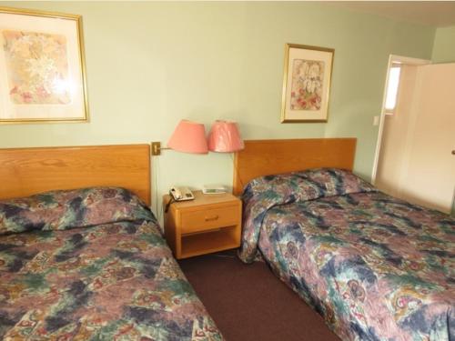 苏圣玛丽萨特莱特汽车旅馆的酒店客房设有两张床和一张桌子及电话