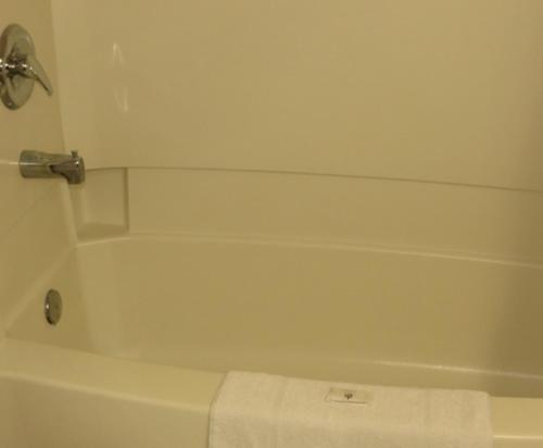苏圣玛丽萨特莱特汽车旅馆的浴室设有白色浴缸,配有毛巾