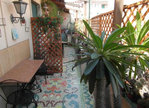 罗马阿比塔兹纳皮吉纳托住宿加早餐酒店的阳台配有桌子和盆栽植物