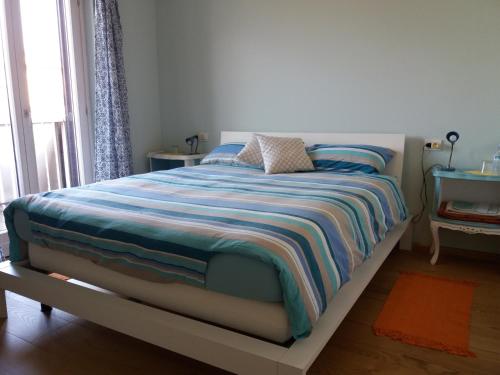 科利科Il Giardino的一间卧室配有带条纹毯子的床