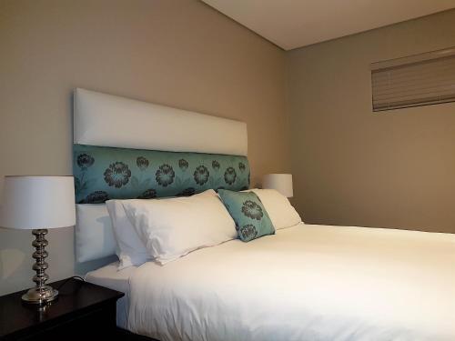 巴利托Zimbali Suites 106的一间卧室配有两张床和两盏灯。