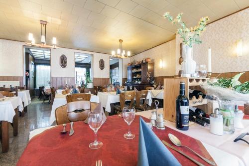 贝尔多夫德法乌酒店的餐厅设有一张桌子,上面放着酒杯
