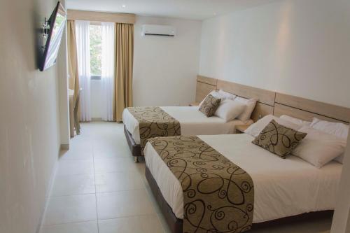 辛塞莱霍Hotel Arawak Plaza的酒店客房设有两张床和电视。