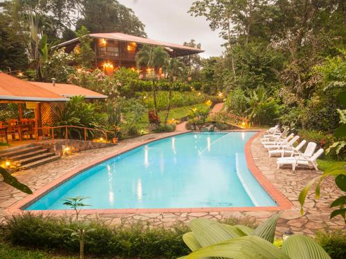 福尔图纳Finca Luna Nueva Lodge的一个带躺椅的游泳池以及一座房子