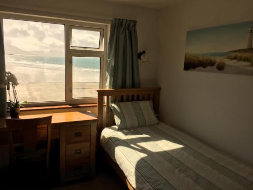 巴利海吉O'Neill's Bed&Breakfast的一间卧室配有一张床、一张书桌和一个窗户。