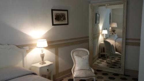 卢卡Luxury apartment Suite La Fontana的一间卧室配有镜子、一张床和一把椅子