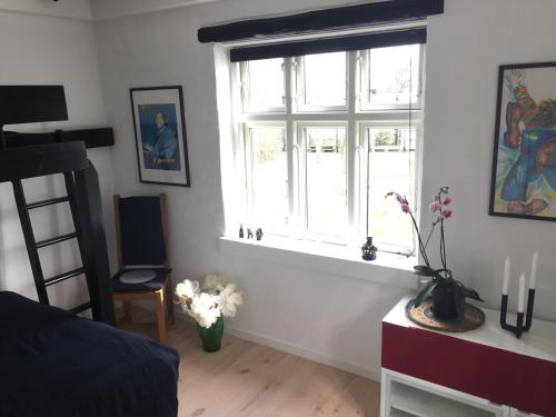 RevningeRevninge Guesthouse的卧室设有窗户和鲜花桌