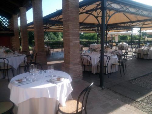 CadèAgriturismo Corte dei Landi的餐厅配有桌椅和白色的桌布