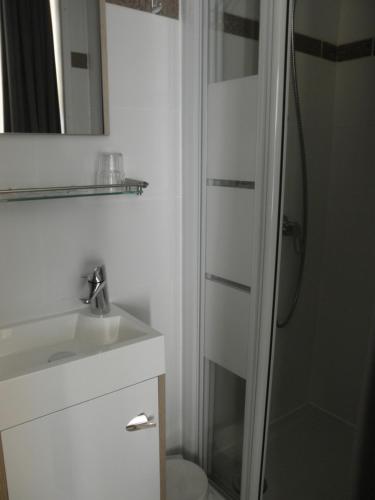 德哈恩Kokodor的白色的浴室设有水槽和淋浴。
