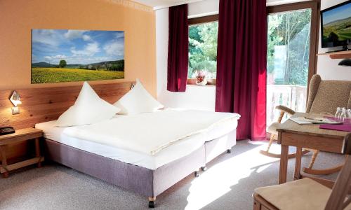 SünnaKelten-Hotel的一间卧室配有一张床、一张书桌和窗户。