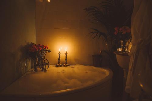 卢恩斯基尔斯奥特奥普别墅酒店的浴室设有浴缸,配以两根蜡烛和鲜花