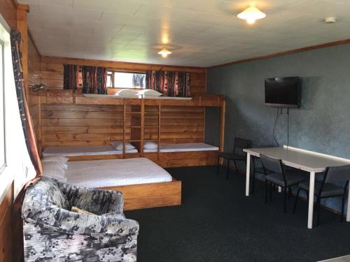 奥克兰埃文代尔汽车公园露营地的配有床、桌子和沙发的房间