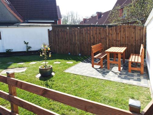不来梅港Fischerhaus Bremerhaven的后院配有桌子和两把椅子以及木栅栏