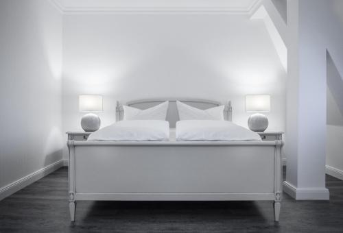 吕本瑙Spreezeit Hotel的白色的房间里一张白色的床,配有两盏灯