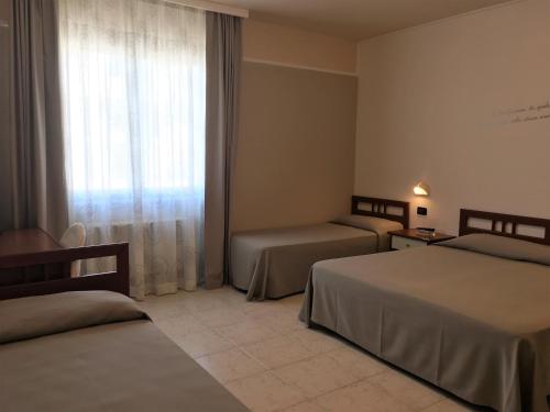 圣乔瓦尼·罗通多欧元酒店的酒店客房设有两张床和窗户。