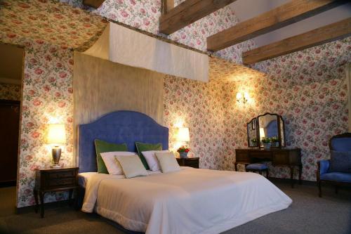 Kaliszki花椰菜庄园酒店的一间卧室配有一张白色大床和蓝色床头板