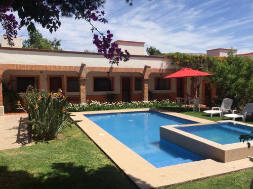 特基斯基亚潘Hotel Los Mezquites的一座房子的院子内的游泳池