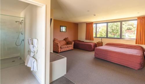 布伦海姆Waterfront motel的一间卧室配有一张床,浴室设有淋浴。