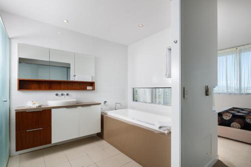 汤斯维尔Central Islington Apartments的白色的浴室设有浴缸和水槽。