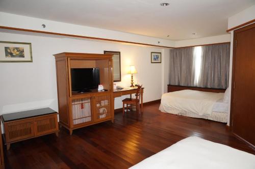 波德申波德申仙境私人度假屋的一间卧室配有一张床和一张书桌及电视