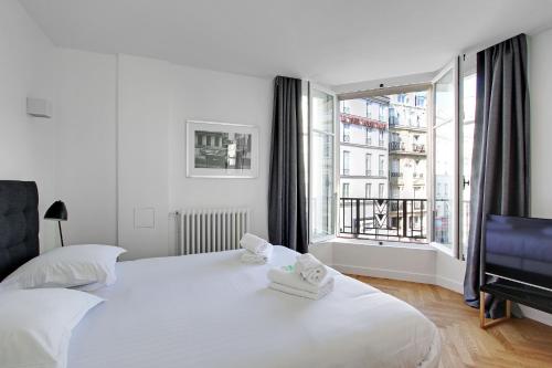 巴黎Pick A Flat's Apartments in Saint Michel - Rue Du Sommerard的卧室设有白色的床和大窗户